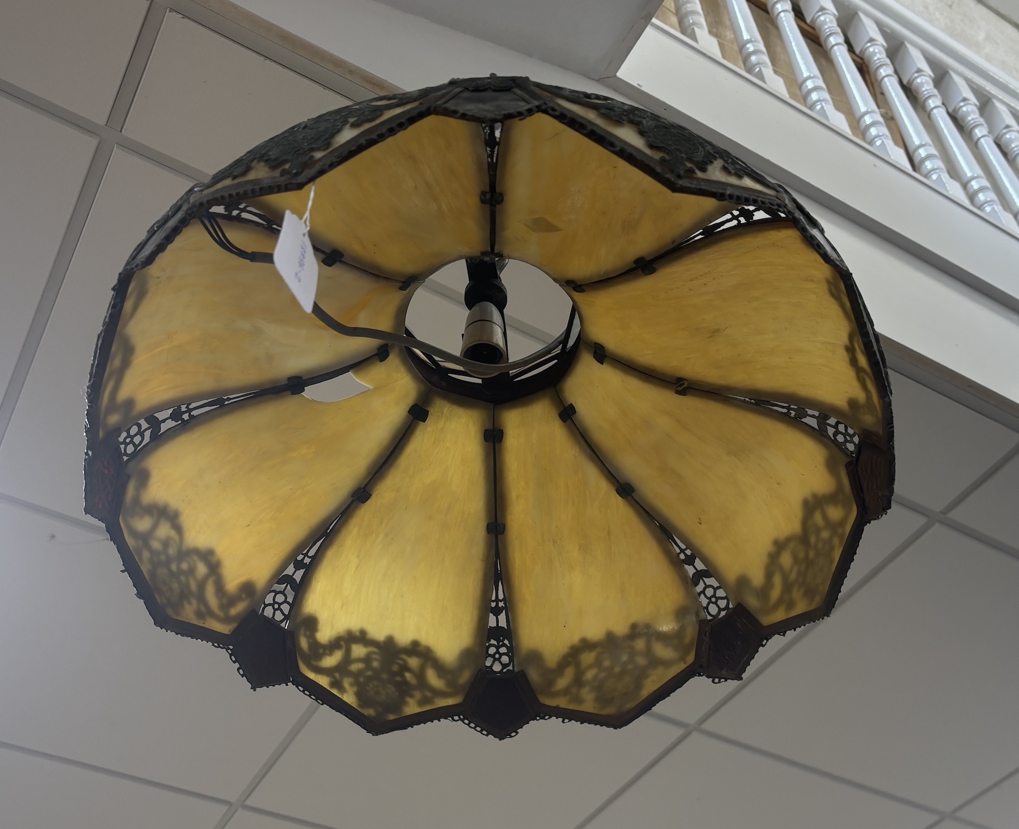 An early 20th century stained glass hanging lamp shade with applied metalwork decoration, shade 56cm diameter
